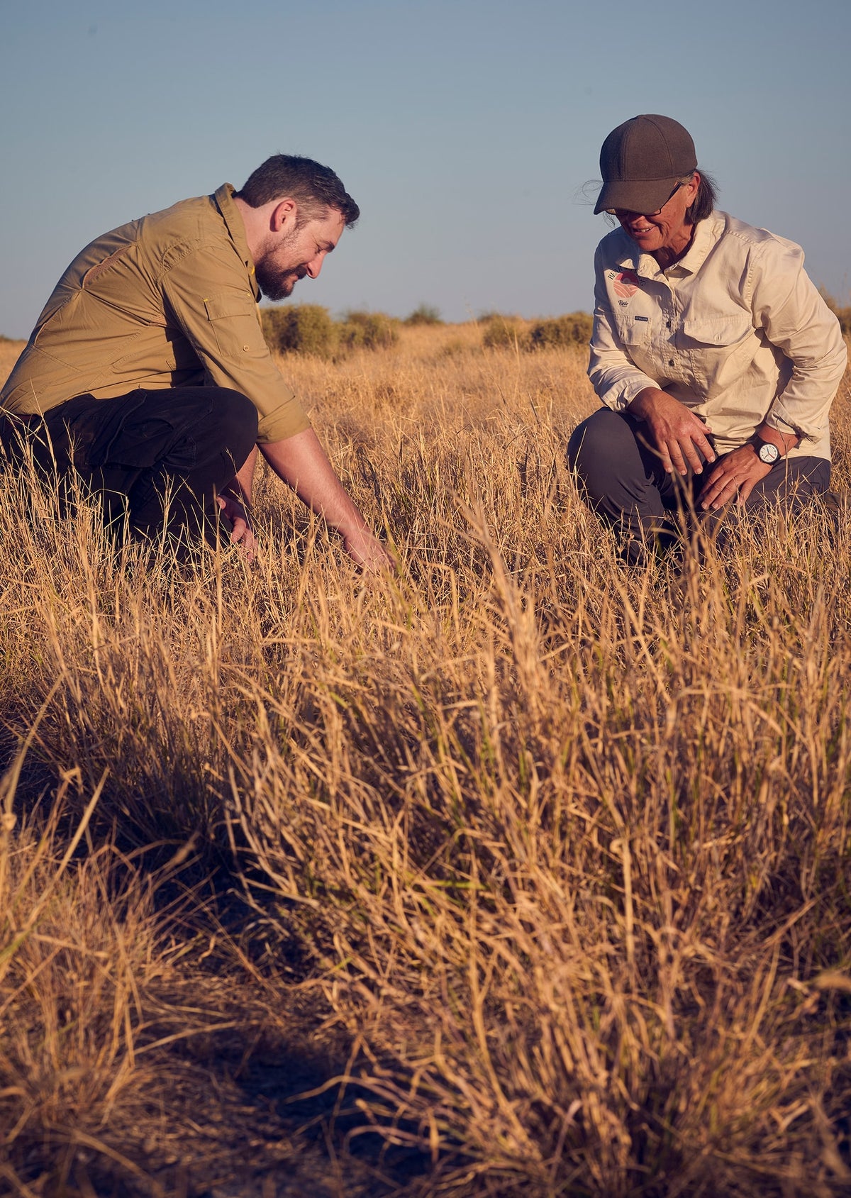 Trust for Nature staff and Jo Bear kneeling in native grassland on the Bear family farm